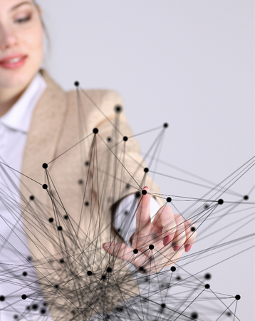 Worldwide network or wireless internet connection futuristic concept. Young woman working with linked dots on grey background.の写真素材