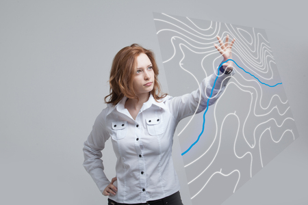 Geographic information systems concept, woman scientist working with futuristic interface in GIS software on a transparent screen.の写真素材