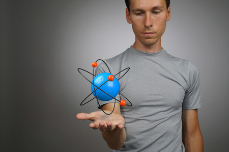 Young man scientist with atom model, research conceptの写真素材