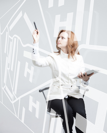 Future technology, navigation, location concept. Woman showing transparent screen with gps navigator map. Future technology, navigation, location concept. Woman showing transparent screen with gps navigator map. Grey background.の写真素材