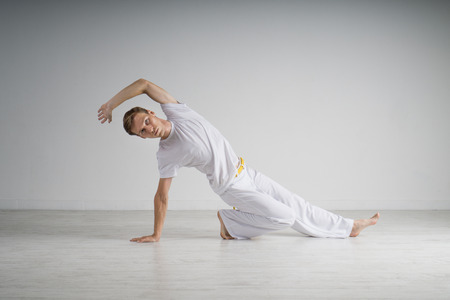 Young Man practicing Capoeira (brazilian martial Art with Elements of Dance, Acrobatics and Music).の写真素材