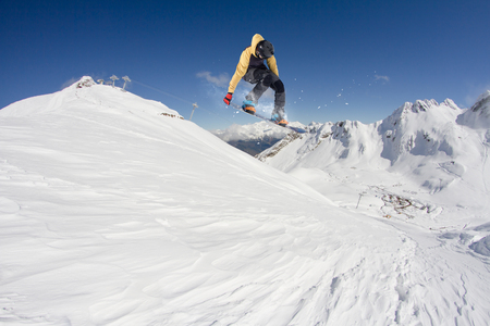 Snowboard rider jumping on mountains. Extreme snowboard freeride sport.の写真素材
