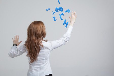 Young woman working with a set of letters, writing concept.の写真素材