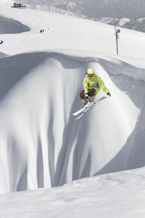 Ski rider jumping on snowy mountains. Extreme ski freeride sport.