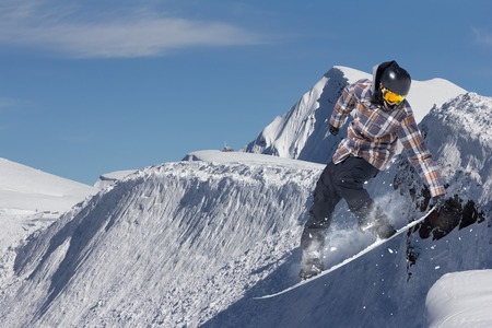 Snowboard rider jumping on mountains. Extreme snowboard freeride sport.