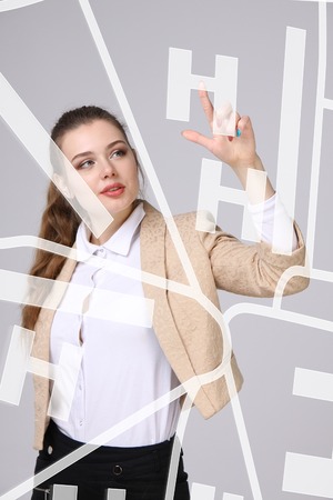 Future technology, navigation, location concept. Woman showing transparent screen with gps navigator map. Grey background.の写真素材