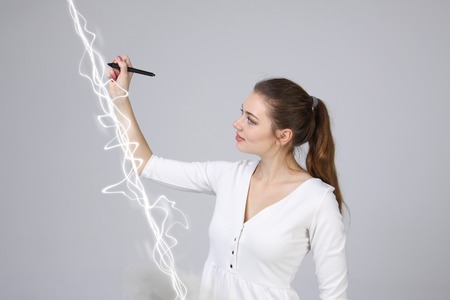 Woman making magic effect - flash lightning. The concept of electricity, high energy.の写真素材