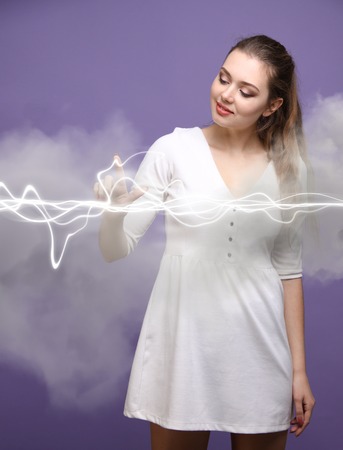 Woman making magic effect - flash lightning. The concept of electricity, high energy.の写真素材
