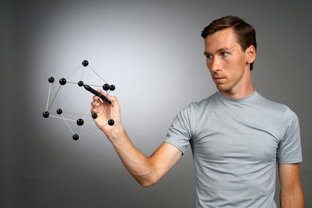 Young man works with a model of molecule.の写真素材