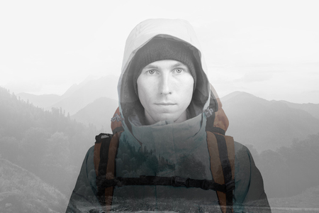 Sunset in the mountains and hiker man with backpack. Double exposure effect photography.の写真素材