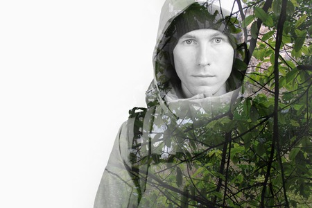 Face of young man hiker and green wild forest. Double exposure effect photography.の写真素材