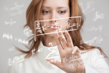 Woman scientist or student working with various high school maths and science formula.の写真素材