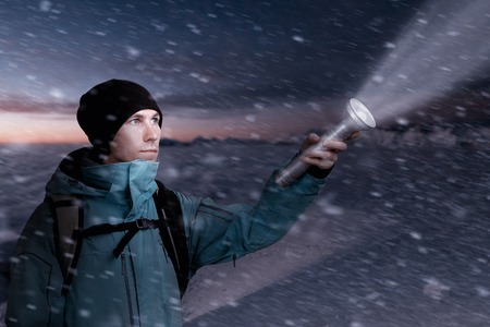 Mountain tourist with a lantern in hand lighting the way in the dark of night.の写真素材