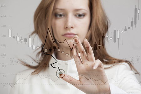 Finance data concept. Young woman working with Analytics. Chart graph information with japanese candles on digital screen.の写真素材