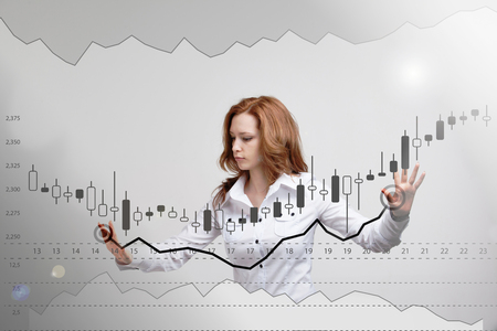 Finance data concept. Woman working with Analytics. Chart graph information with Japanese candles on digital screen.の写真素材