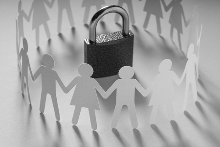 Human paper figures standing around padlock on a white surface. Freedom, human rights, independence.の写真素材