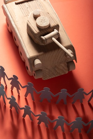 Raw of paper people rallying in front of a tank. Protest, demonstration toy concept.の写真素材