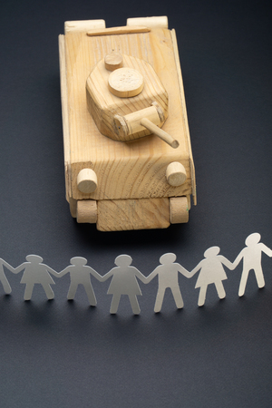 Raw of paper people rallying in front of a tank. Protest, demonstration toy concept. Activism, social movement.の写真素材