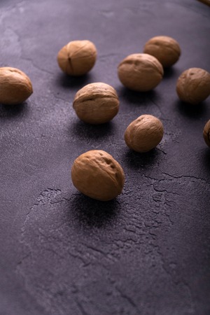 Bunch of whole walnuts on dark blue slate background. Healthy diet composition.の写真素材