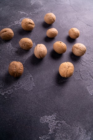 Bunch of whole walnuts on dark blue slate surface. Healthy diet composition.の写真素材
