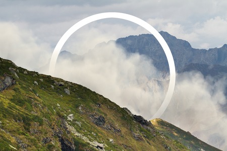 White circle in the middle of foggy mountain landscape. Natural and unkown.の写真素材