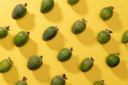 Fruit pattern of fresh feijoa fruits against yellow background. Top view pop art minimal flat lay style.の写真素材