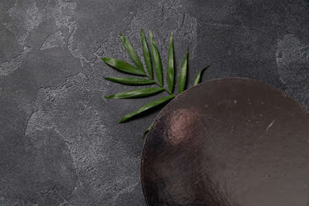 Green plant leaf on dark concrete background. Flat lay, top view, minimal design template with copyspaceの写真素材
