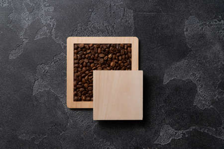 Coffee beans in wooden box on a dark background.の写真素材
