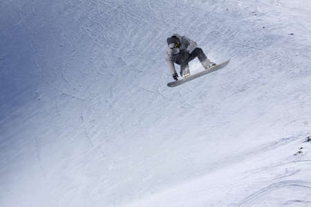 Snowboarder flying on the background of snowy slope. Extreme winter sports, snowboarding.の写真素材