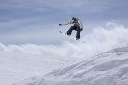 Snowboard rider jumping on mountains. Extreme snowboard freeride sport.の写真素材