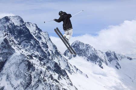 Flying skier on mountains. Extreme winter sport.の写真素材