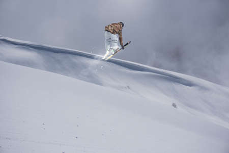 A jumping skier in the mountains. Mountain ski, winter extreme sport.の写真素材