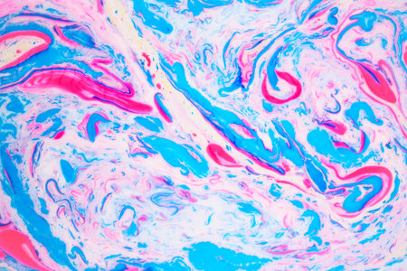Variegated colored background, paint particles on white. Dye stains on the surface of the liquid....