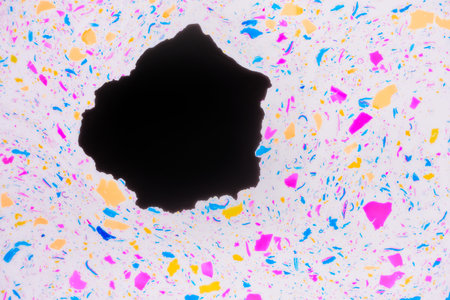 Colorful terrazzo texture. Multicolored spots and inclusions on a white and big black stain....