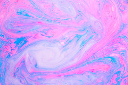 Abstract colored marble background, stains of pink and blue paint on the surface of the water. Liquid colorful backdrop.の写真素材