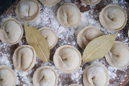 Meat or vegeterian dumplings, pelmeni on a wooden board. Russian national food. Close up top view.の写真素材