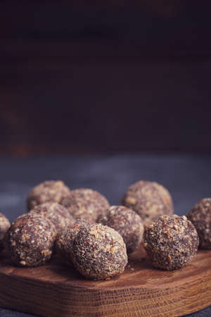 Healthy homemade energy balls on wooden plate. Vegan candies, sweets made of nuts and dates.の写真素材