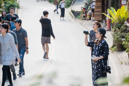 Chiangmai, Thailand - Nov 25 : Woman taking a photo with a camera  at Ban MaeKamPong village on Nov 25, 2016 in Chiangmai, Thailandのeditorial素材
