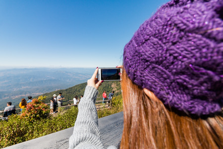 Woman taking photos with smartphone at Doi Inthanon National Parkの写真素材