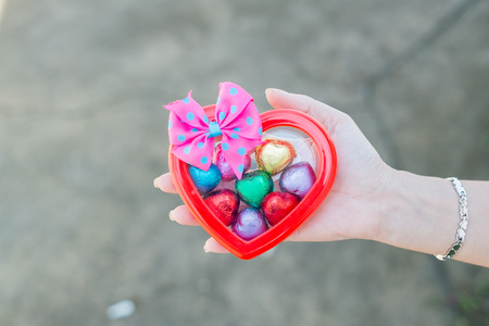 Hand of a young woman holding a chocolate heart shapedの写真素材