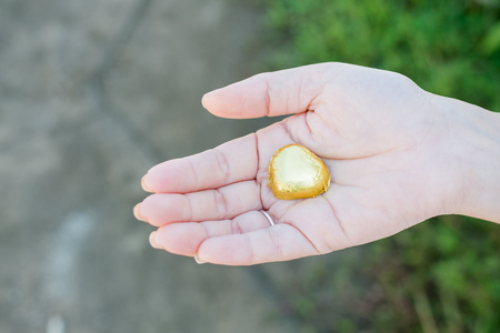 Hand of a young woman holding a chocolate heart shapedの写真素材