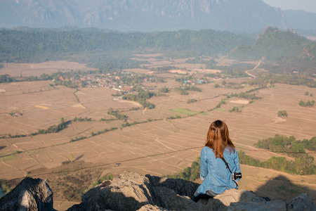 Young woman enjoy the view at Phanegun in Vangvieng, Laosの写真素材