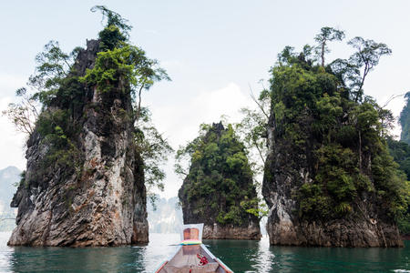 Long tail boat among mountains and clear water in the Cheow Lan Dam or Ratchaprapa Dam, Khao Sok national park, Surat Thani, Thailandの写真素材
