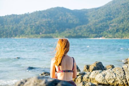 Happy Girl Enjoying Beautiful Sunrise on the beach in Satun, Thailand