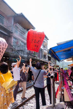Taipei, Taiwan - Many peopleare Launching Sky Lantern Along Railway  at Shifen Old Street,Taiwan. on...