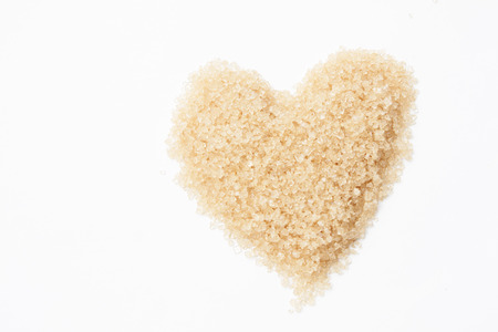 valentine heart of sweet brown sugar on white backgroundの写真素材