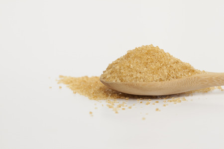 Brown sugar in wooden spoon on white background.の写真素材