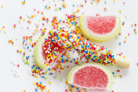 colorful sweet candy, very small colored sugar ball with shortbread stick and water melon shaped jellies on white background.の写真素材