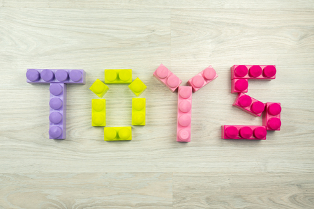 the word toys spelled with blocks, on a wooden background. Can be used as a backgroundの写真素材