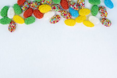 Top view of colored candy on a white background with space next to itの写真素材